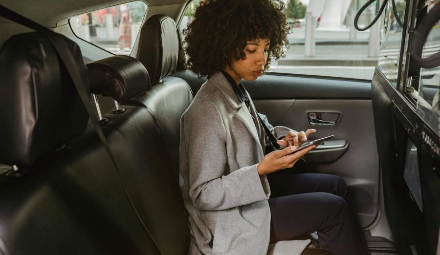 C'est une femme dans une voiture avec un téléphone